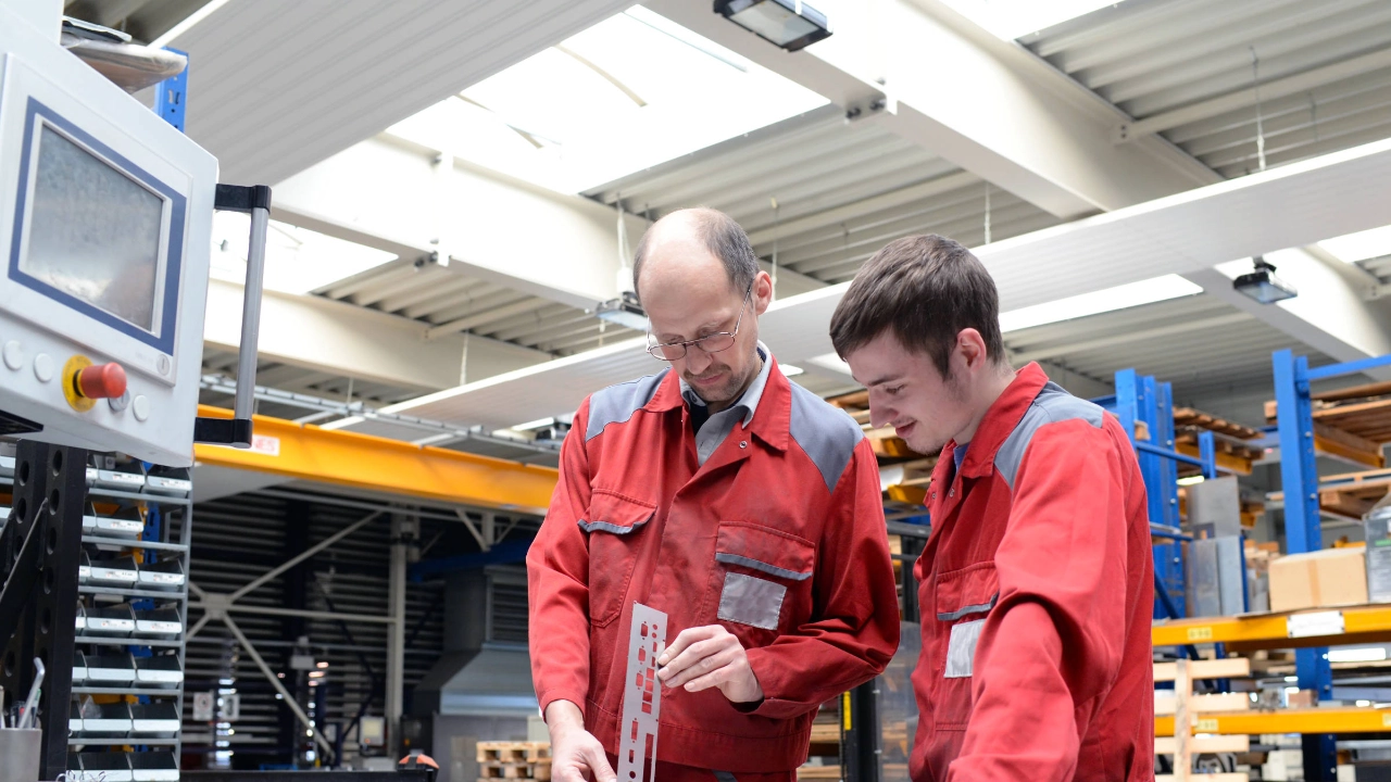 Auszubildender und Ausbilder in einem metallverarbeitenden Unternehmen.