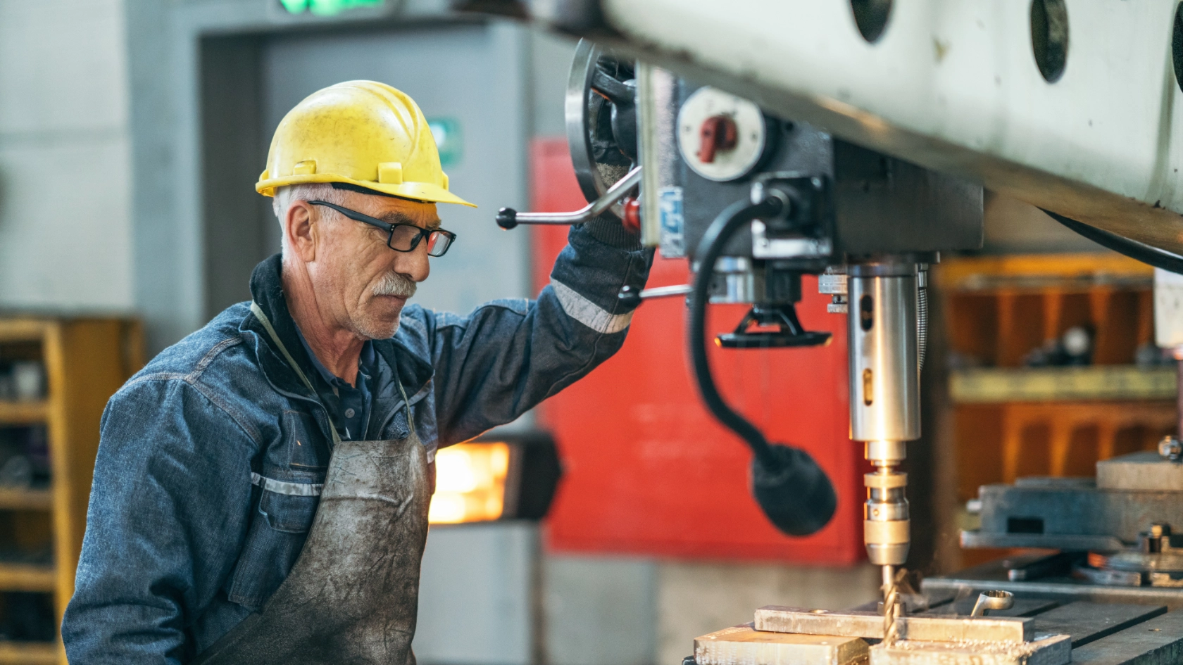 Arbeiter in einer Werkstatt an einer Bohrmaschine