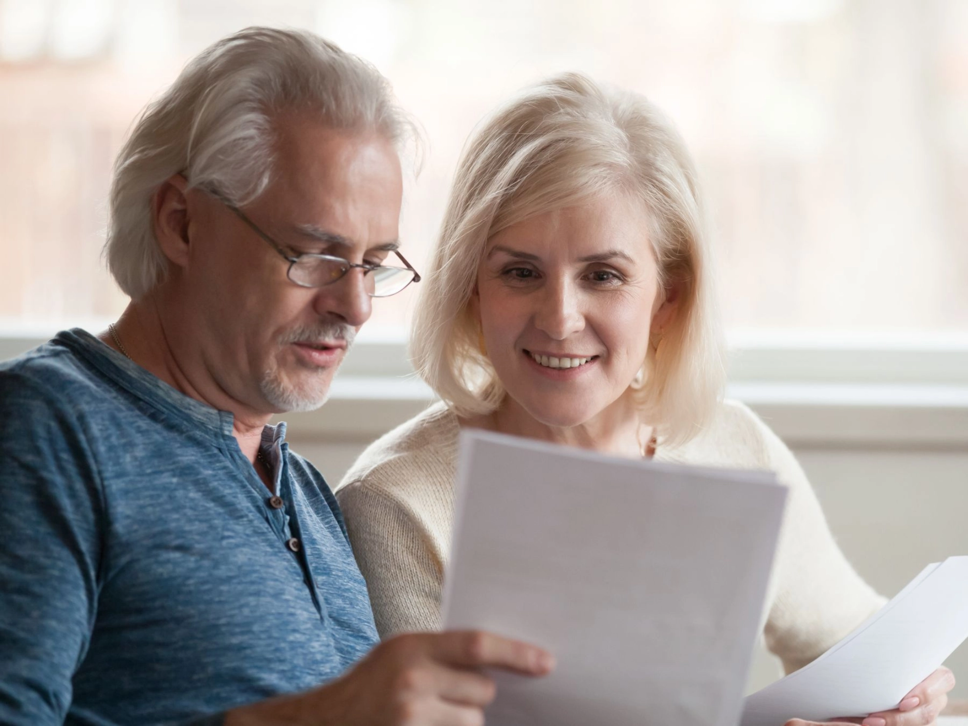 zwei ältere Menschen betrachten gemeinsam Unterlagen